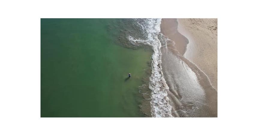 Aerial top-down drone video of a fisherman fishing on the Jimbaran beach at Bali, Denpasar, Indonesi