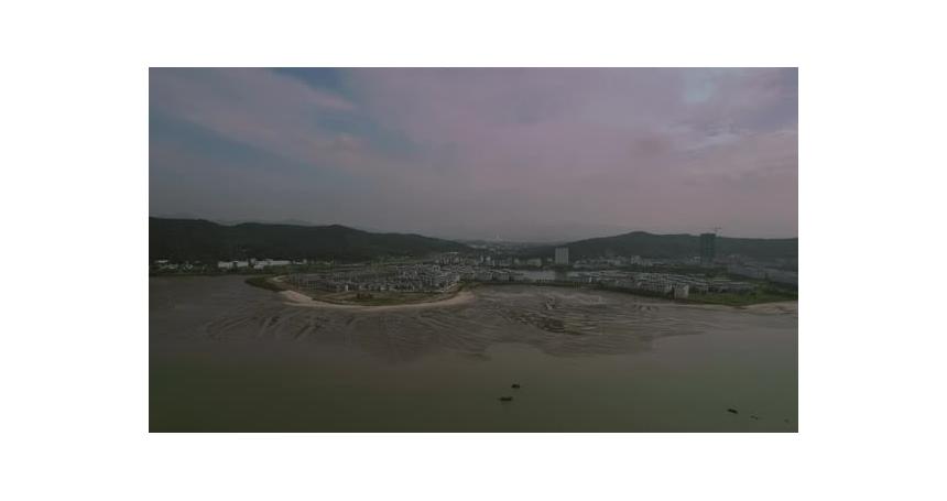 Approaching aerial movement to the coastal suburban bay with populated area, Ha Long, Vietnam.